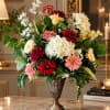 Large mixed flower arrangement in a decorative urn vase