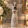 Angel figurine holding a flower with a sympathy message