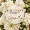 White sympathy floral arrangement with a round designer choice sign