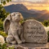 Memorial dog statue beside a stone plaque with engraved text
