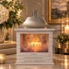 Memorial lantern with a candle and floral scene inside