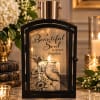 Black memorial lantern with a lit candle and the words "A Beautiful Soul is never forgotten."