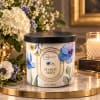 Floral-scented candle in a decorated jar with a black lid