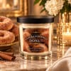 Scented candle in a glass jar with a black lid and donut label