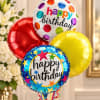 Cluster of colorful happy birthday balloons in front of flowers