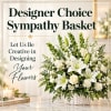 White sympathy basket with lilies, roses, and small white blooms in a wicker basket