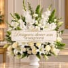 White floral urn arrangement with lilies and roses in a white vase