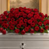 Large arrangement of red roses on a silver casket