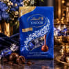 Bag of Lindt dark chocolate truffles with wrapped chocolates and flowers nearby