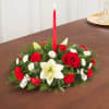 Low floral centerpiece with a red taper candle and red, white blooms