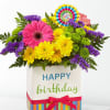 Birthday flower arrangement in a striped gift box with a ribbon