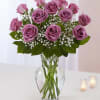 Pink roses arranged in a clear glass vase with baby's breath
