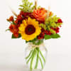 Sunflower and orange rose bouquet in a clear glass vase