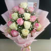 Bouquet of pink and white roses wrapped in pale pink paper