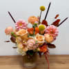 Peach and pink floral arrangement in a ribbed glass vase