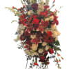 Tall standing floral spray with red, white, and burgundy blooms
