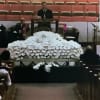Large white floral casket spray in a church setting