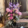 Tall bouquet of pink and purple flowers in a black vase