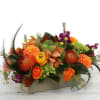Orange and purple floral arrangement in a rectangular box