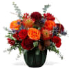 Red and orange floral arrangement in a dark vase