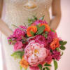 Bride holding a bright pink and orange bouquet