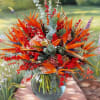 Tropical bouquet with orange bird-of-paradise flowers in a glass vase