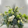 Large floral arrangement in a silver urn with white orchids and green blooms