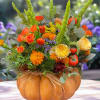 A pumpkin floral design is a charming and creative arrangement that combines