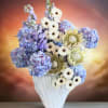 Blue hydrangeas and white daisies in a white vase