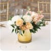 Peach and white rose arrangement in a gold glass vase