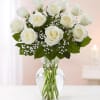 White roses arranged in a clear glass vase with baby's breath