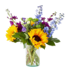 Bouquet of sunflowers, blue delphinium, and purple flowers in a glass vase