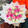 Bouquet of pink and white roses wrapped in white paper