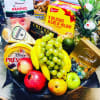 Gift basket with fruit, cheese, chocolates, and a pineapple centerpiece