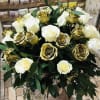Bouquet of white and gold roses with dark green foliage