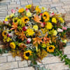 Large floral spray with sunflowers, roses, lilies, and yellow blooms