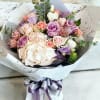 Bouquet of pastel roses and hydrangeas wrapped in white paper