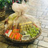 Gift basket with candy, fruit, and snacks wrapped in tulle