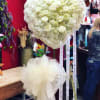 A large, heart-shaped sympathy standing spray arranged in serene whites and pale