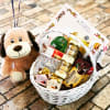 Gift basket with cookies, chocolates, and a plush dog