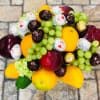 Fruit arrangement with grapes, mangoes, apples, and wrapped chocolates