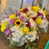 Mixed bouquet with sunflowers, chrysanthemums, and white hydrangeas in a vase