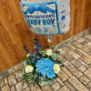 Blue baby boy balloon above a blue and white flower arrangement