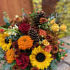 Mixed bouquet with red roses, sunflowers, and orange blooms in autumn colors