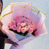 A generous cluster of soft pink Roses gathered into a rounded, hand-tied
