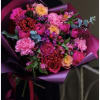 Bouquet of pink and peach roses with carnations wrapped in purple paper