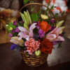 A cheerful hand-tied flower arrangement in a small woven basket, Little Basket