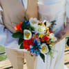 Bride and groom holding a colorful bouquet with roses and tulips