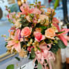 Pink and peach bouquet with lilies, roses, and ribbon