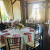 Round banquet tables with pink napkins and floral centerpieces in a bright room